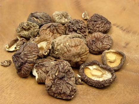 Dried shiitake mushrooms arranged on brown wooden board