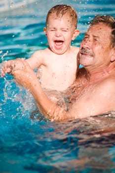 Grandfather swimming with grandson