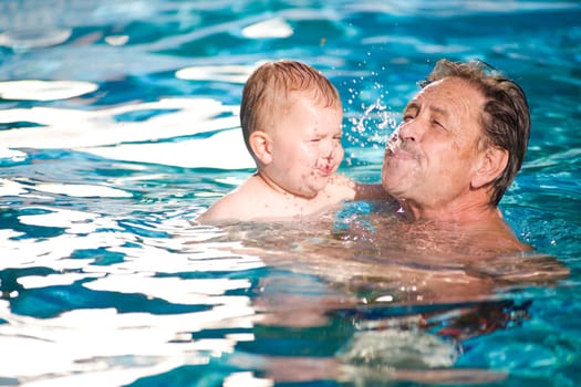 Grandfather swimming with grandson