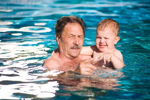 Grandfather swimming with grandson