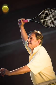 Senior man playing tennis