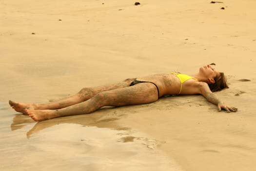 Woman lying on the beach at sunset