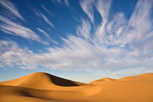 desert dunes with cloudy blue sky