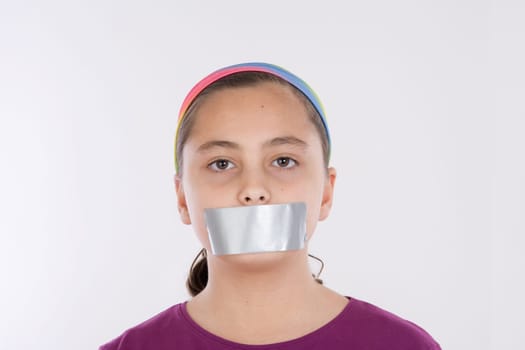 Angry girl with adhesive on her mouth