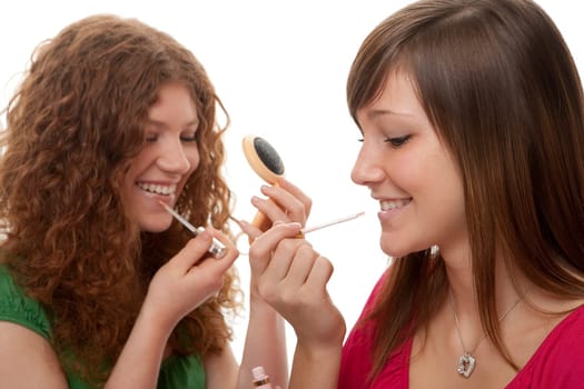 Female teens putting on make-up