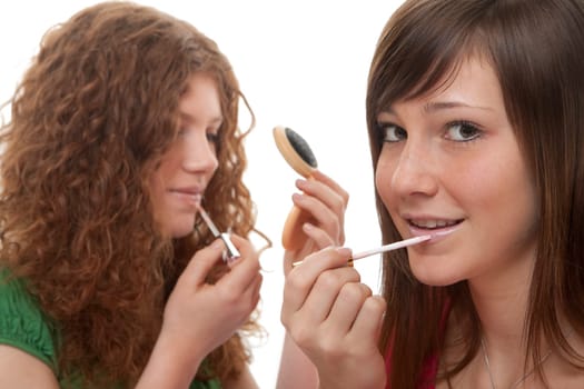 Female teens putting on make-up