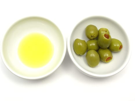 Two porcelain bowls with olive oil and olives