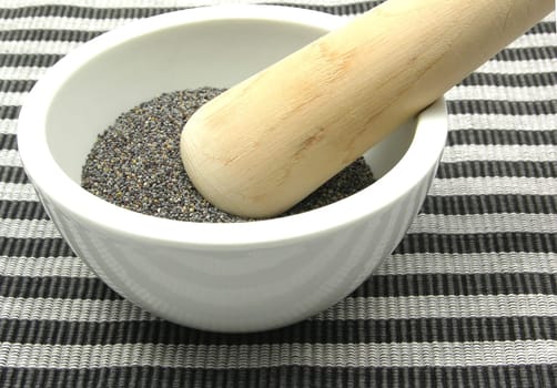 Poppy seeds in porcelain bowl with mortar