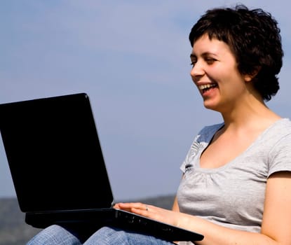 Young casual woman working on laptop