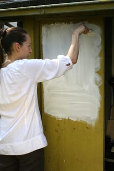 Woman paints wall