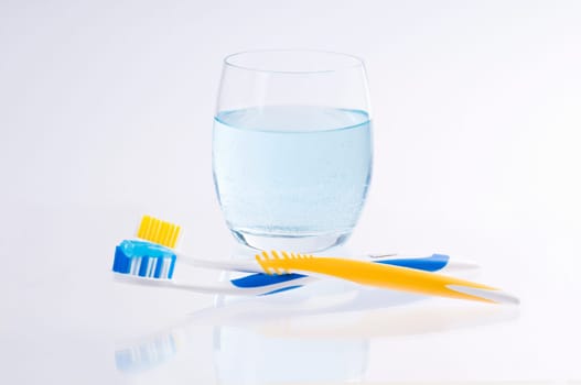 two toothbrushes with water glass