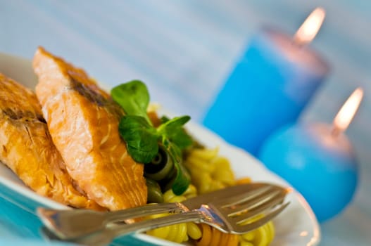 Salmon fillet with noodles served on plate