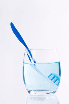 Toothbrush in a glass of water with mouthwash
