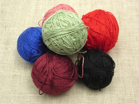 Balls of wool stacked on a beige background
