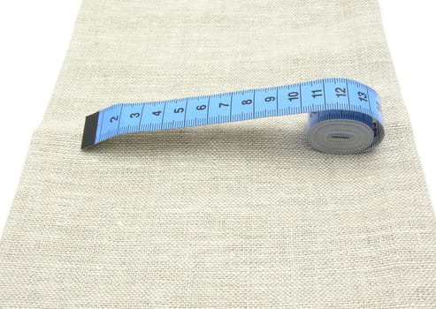 Blue Unrolled Tape Measure on Linen Fabric