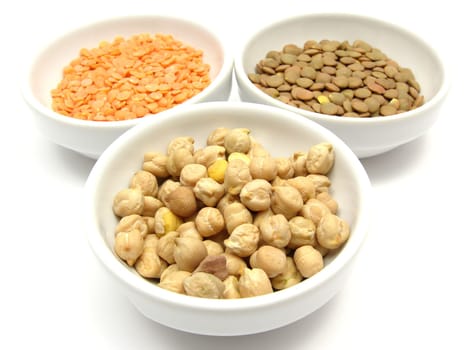 Three porcelain bowls with chickpeas,red and plate lentils