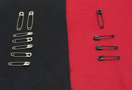 Safety pins on black and red felt