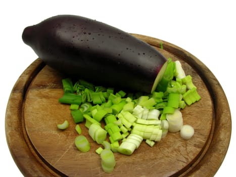 Eggplant and sliced spring onion on wooden board