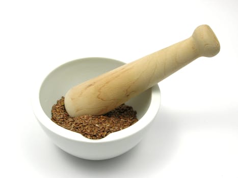 Dried flaxseed in porcelain bowl with mortar