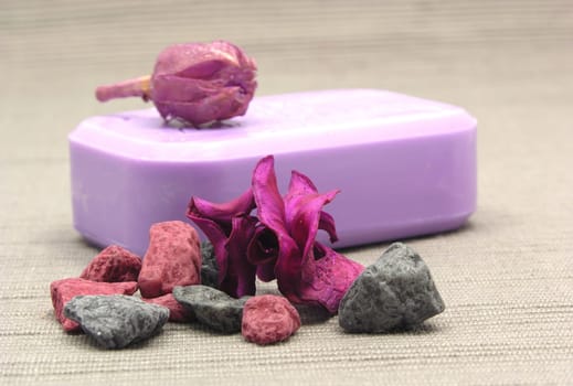 Purple soap with decorative items against gray background
