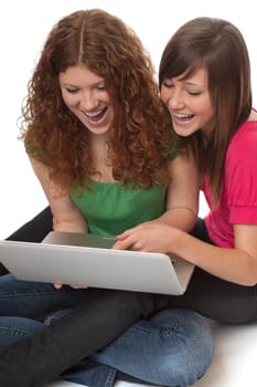 Two teenagers using laptop