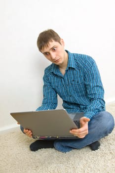 man sitting on the floor using a laptop
