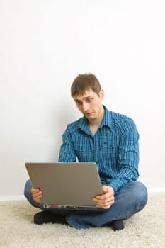 man sitting on the floor using a laptop