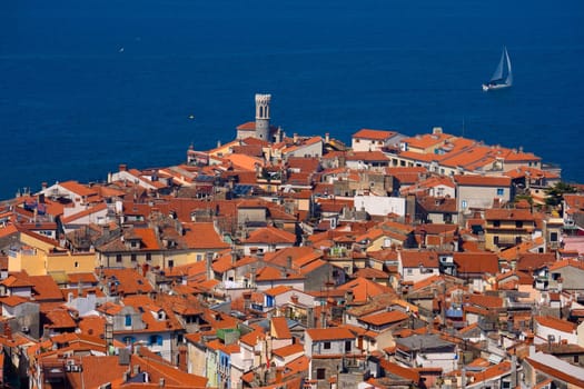 Roofs of a typical southern European town and a sailboat