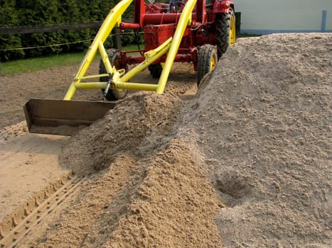 Vintage tractor pushes sand wide