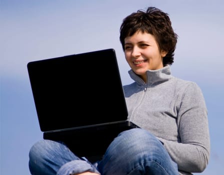 Young casual woman working on laptop
