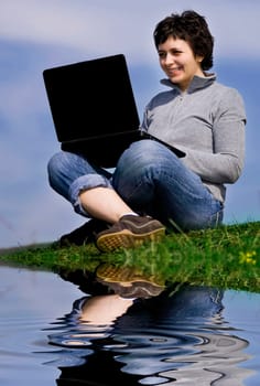 Young casual woman working on laptop out