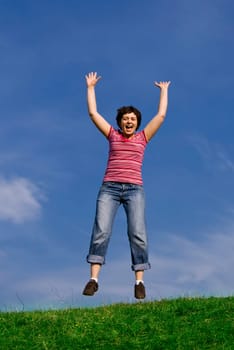 Young happy woman jumping high against b
