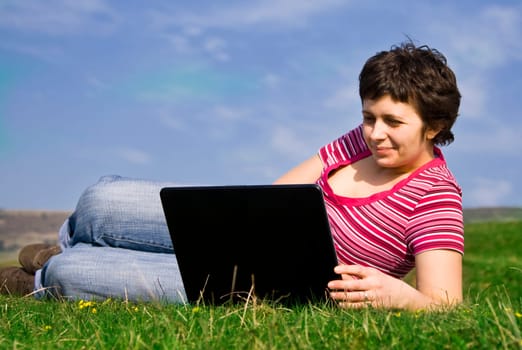 Young casual woman working on laptop