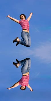 Young happy woman jumping high against b