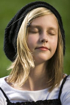 Blond young girl sitting in the grass
