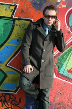 Serious man talking on the phone outdoors