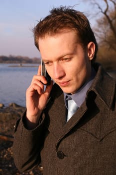 Serious man talking on the phone outdoors