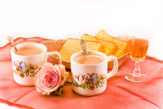 Two mugs of coffee with cake and amaretto