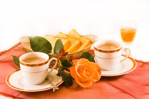 Two cups of coffee with cake and amaretto