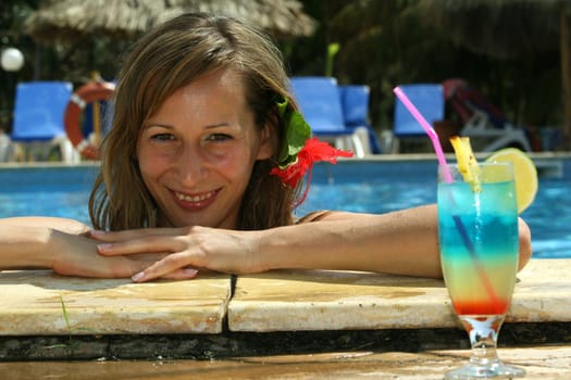 Woman in pool with cocktail