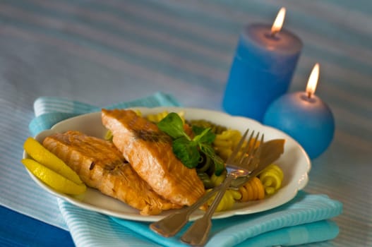 Salmon fillet with noodles served on plate