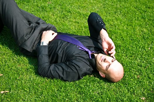 businessperson on the phone relaxing in the grass
