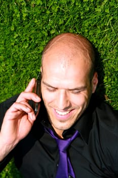 businessperson on the phone relaxing in the grass