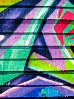 Vibrant graffiti on wood slatted wall