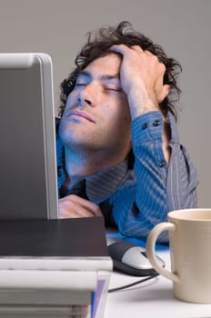 tired man at computer desk with coffee