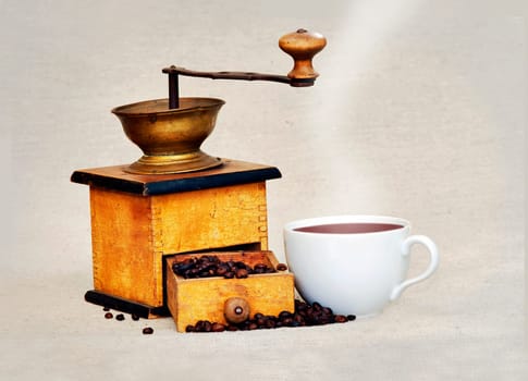 coffee mill and cup of hot black coffee