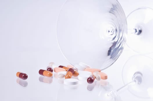 Various tablets in cocktail glass on white background