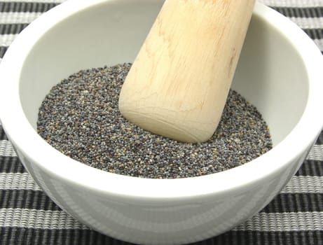 Poppy seeds in porcelain bowl with mortar