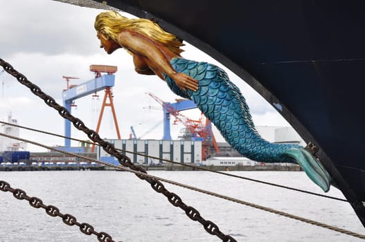 a figurehead of a ship against the backdrop of the port of Kiel