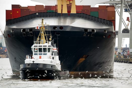 tugboat towing freighter in harbor